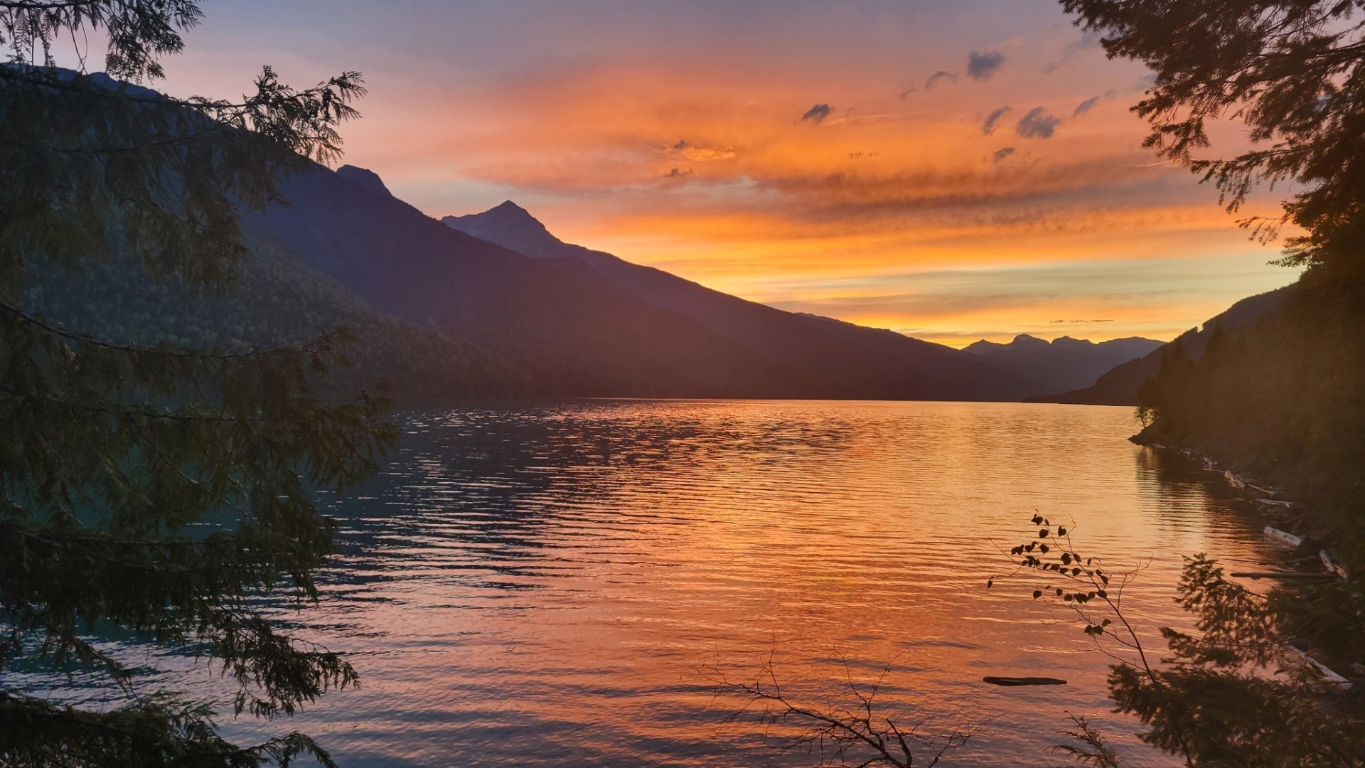 Revelstoke Lake at sunset with mountains in the background.